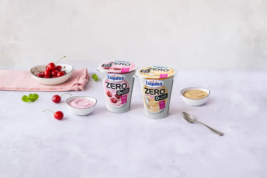 Mehrere Exquisa ZERO Produkte mit frischen Früchten auf hellem Hintergrund.