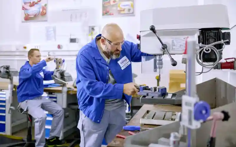 Zwei Techniker arbeiten an Maschinen.