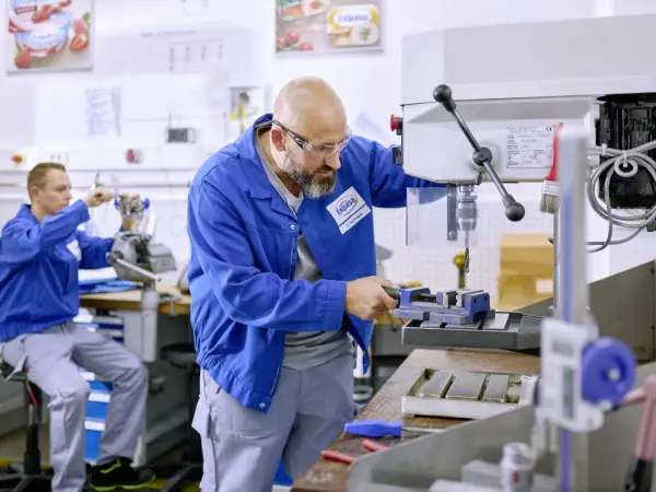 Zwei Techniker arbeiten an Maschinen.