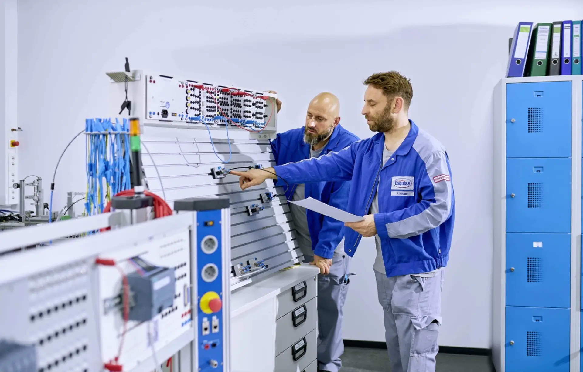 Zwei Mitarbeitende der Technik stehen an einem Elektropult und arbeiten.