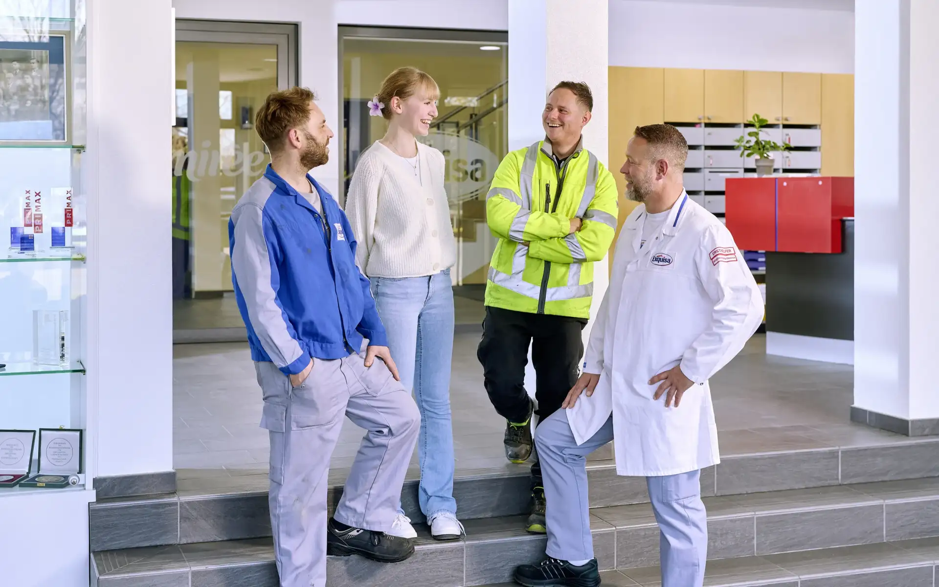Vier Karwendel-Mitarbeitende im lachenden Gespräch in der Empfangshalle.