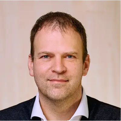 Portrait der Leitung Rohstoffmanagement Johannes Lenz vor hellem Hintergrund.