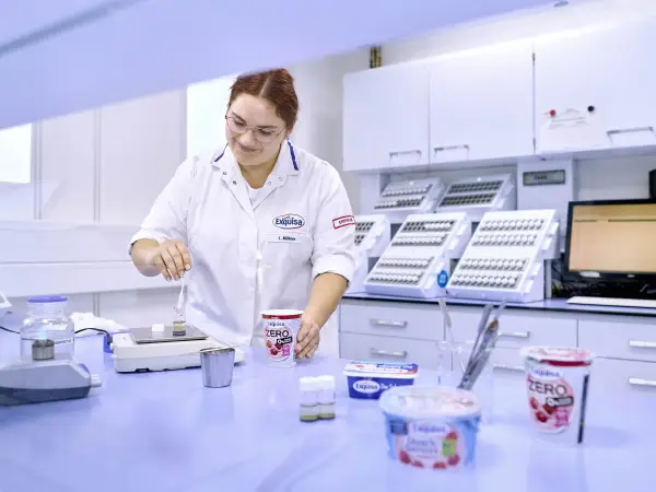 Labor Mitarbeitende steht im Labor an einem Tisch und kontrolliert die Produktqualität.