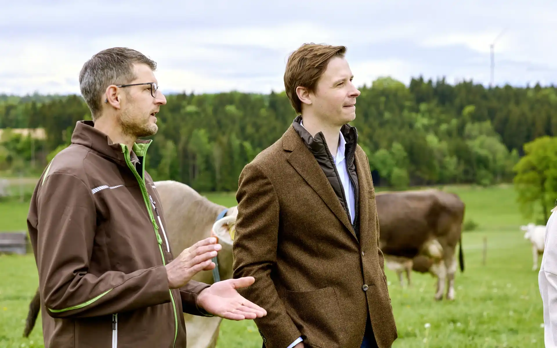 Ein Karwendel Landwirt steht mit dem Geschäftsführer Viktor Lindner auf einer Weide in einer Besprechung.