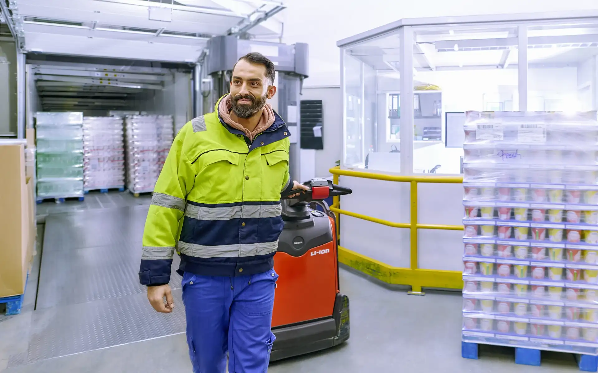 Ein Mitarbeiter der Logistik fährt mit einer Logistik-Ameise durch das Kühllager.