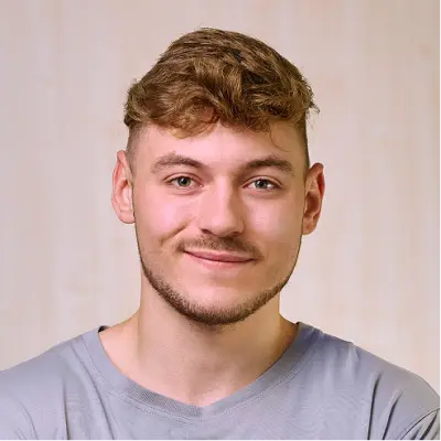 Portrait von Ausbilder Simon Düring vor einem hellen Hintergrund.