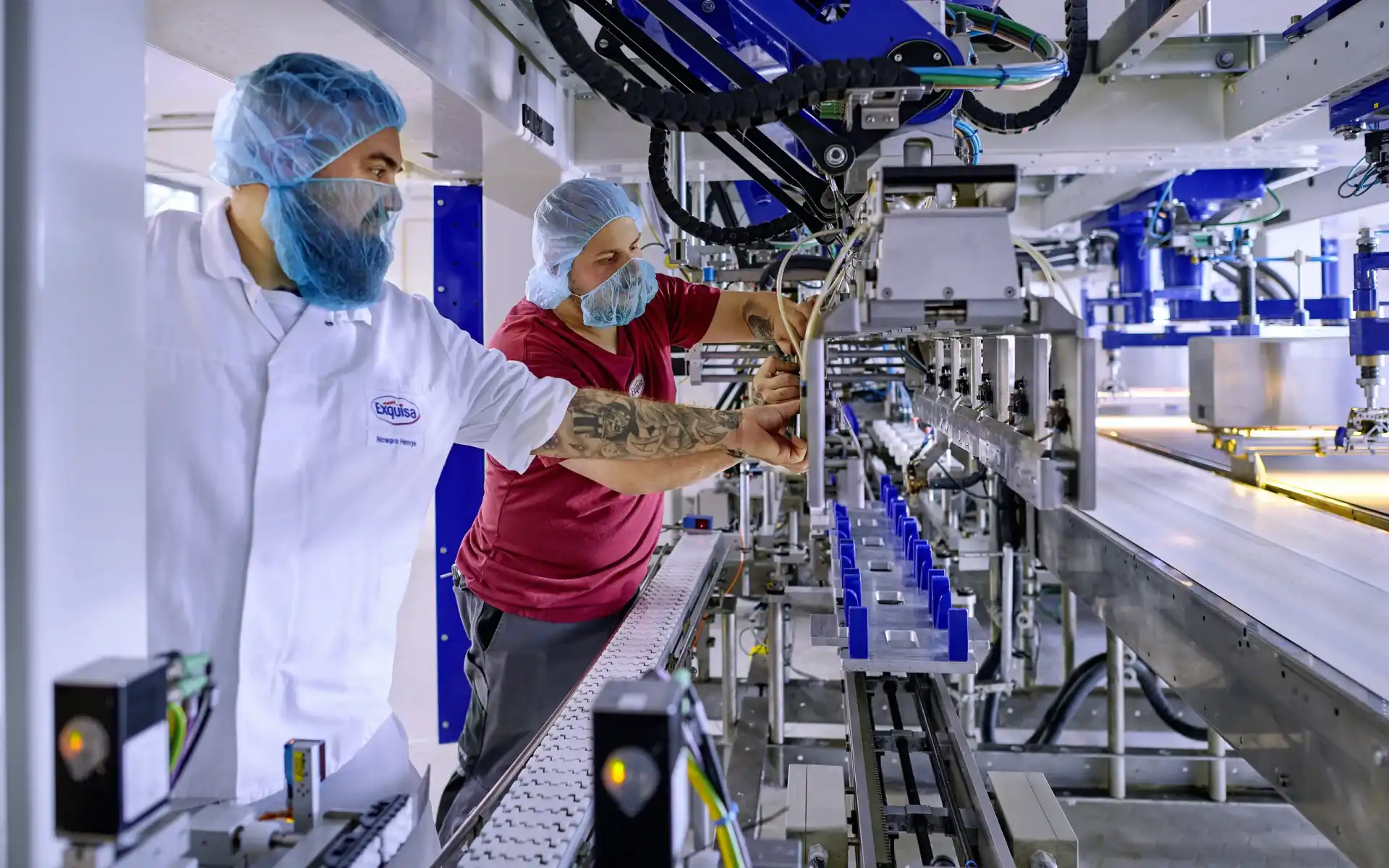Zwei Mitarbeitende warten in der Produktion eine Produktionslinie.